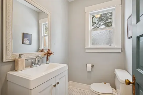 a bathroom with a toilet sink and mirror