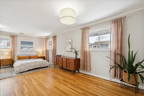 a spacious bedroom with a bed and wooden floor