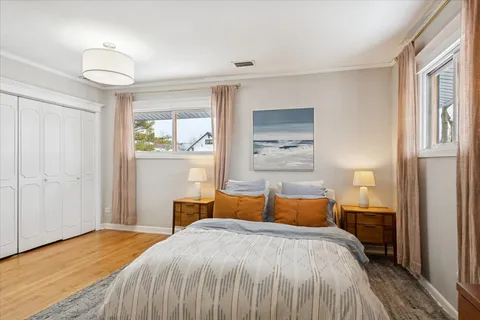 a bedroom with a bed and wooden floor