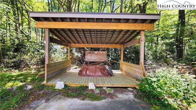 a backyard of a house with plants and large tree