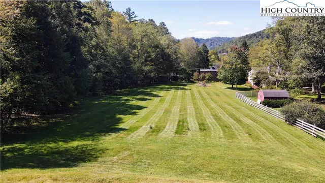 an aerial view of residential house with outdoor space and trees all around