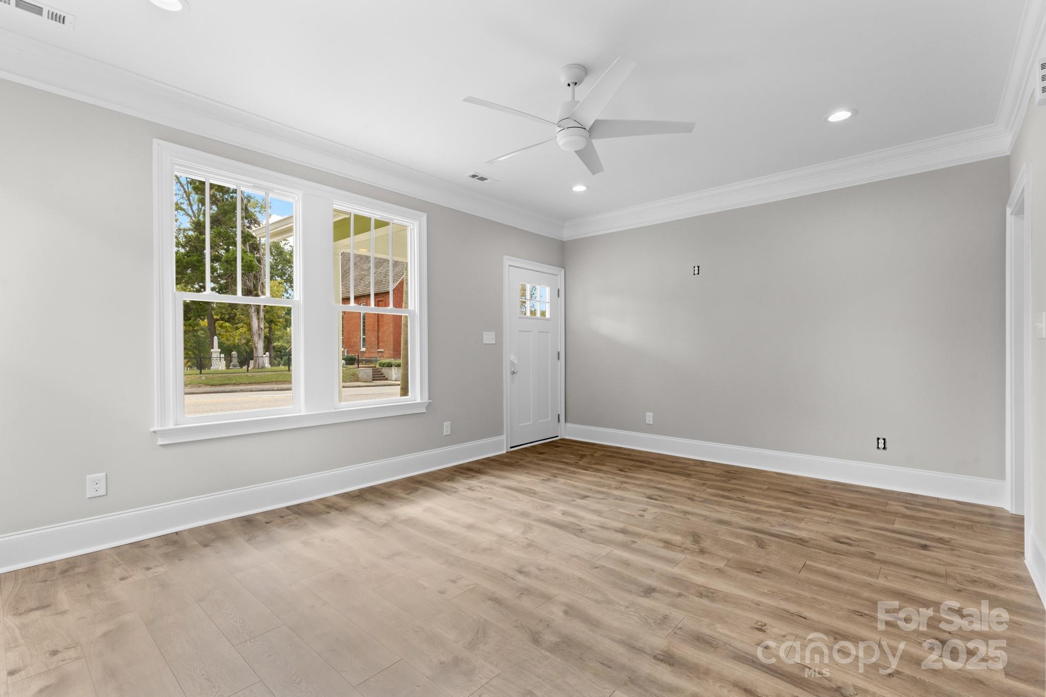302 West Gay Street Lancaster, SC 29720 - Photo 6 of 26 a view of an empty room with a window and wooden floor