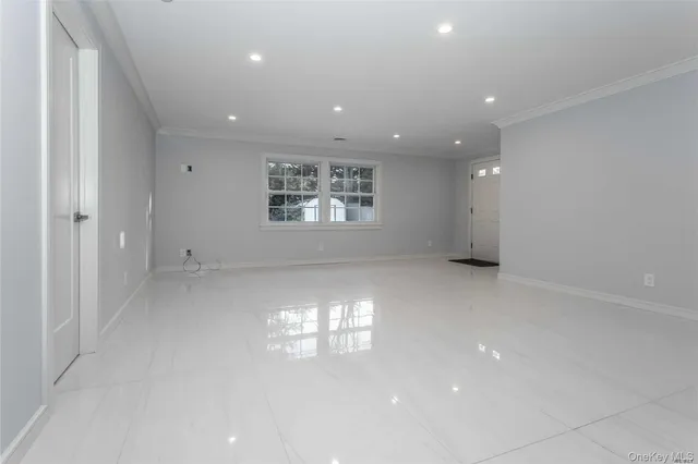 an empty room with windows and ceiling fan