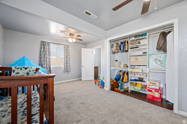 348 North Lodge Road Central, UT 84722 - Photo 7 of 25 Bedroom with dark colored carpet, ceiling fan, a crib, and a closet