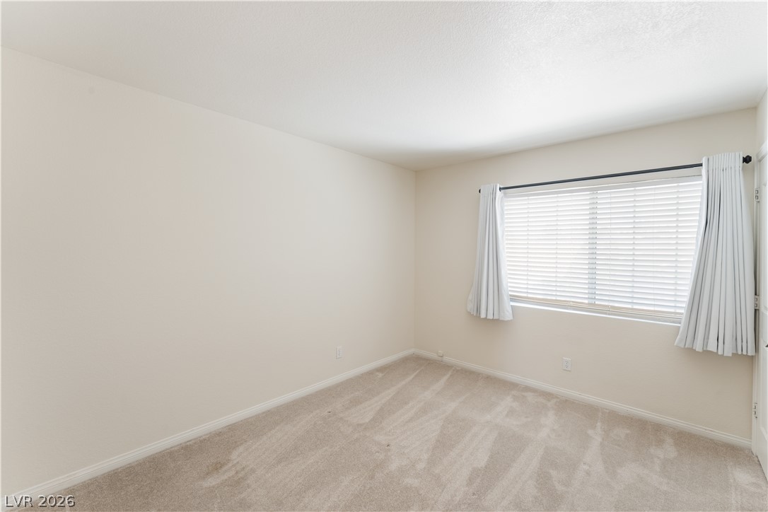 8872 Chapman Point Las Vegas, NV 89129 - Photo 22 of 29 Comfortable carpeted bedroom with a window offering natural light.