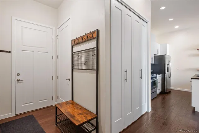 a view of a hallway with wooden floor and closet area
