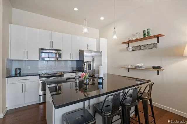 a kitchen with stainless steel appliances granite countertop a sink a stove and a refrigerator