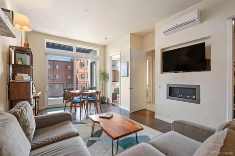 a living room with furniture a flat screen tv and kitchen view