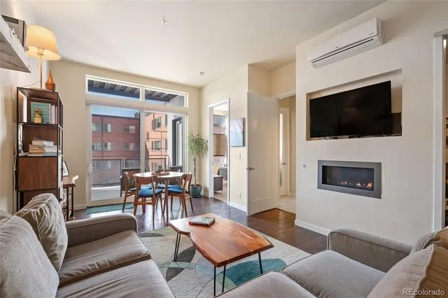a living room with furniture a flat screen tv and kitchen view
