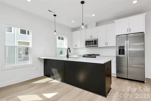 a kitchen with stainless steel appliances a stove microwave and refrigerator