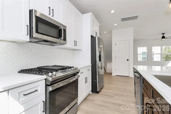 a kitchen with stainless steel appliances granite countertop a sink a stove and microwave