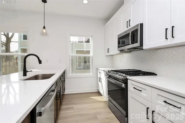a kitchen with a sink stove and microwave