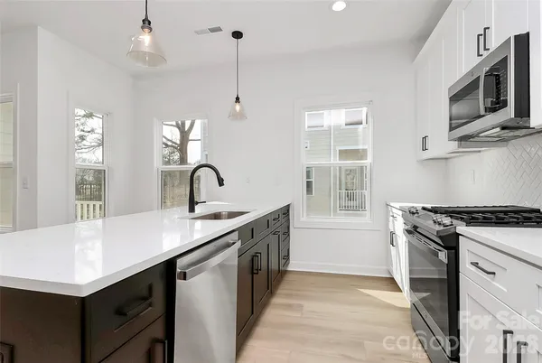 a kitchen with stainless steel appliances a sink stove and refrigerator