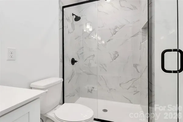 a view of a kitchen with refrigerator and wooden floor