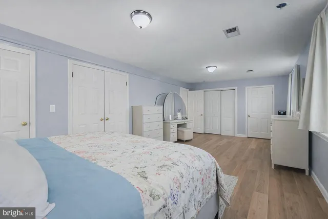 a spacious bedroom with a bed and a refrigerator