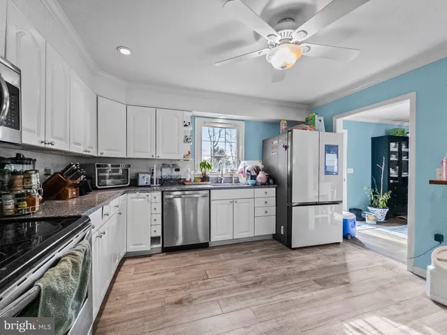 a kitchen with refrigerator cabinets and wooden floor