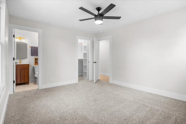 an empty room with closet and a ceiling fan