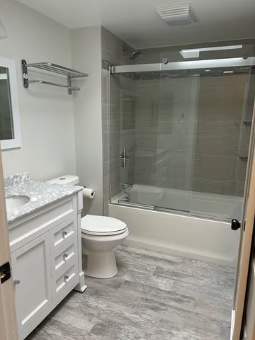 a bathroom with a granite countertop toilet a sink and bathtub
