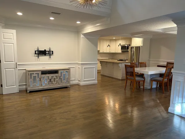 a view of a kitchen with kitchen island a sink stainless steel appliances and cabinets