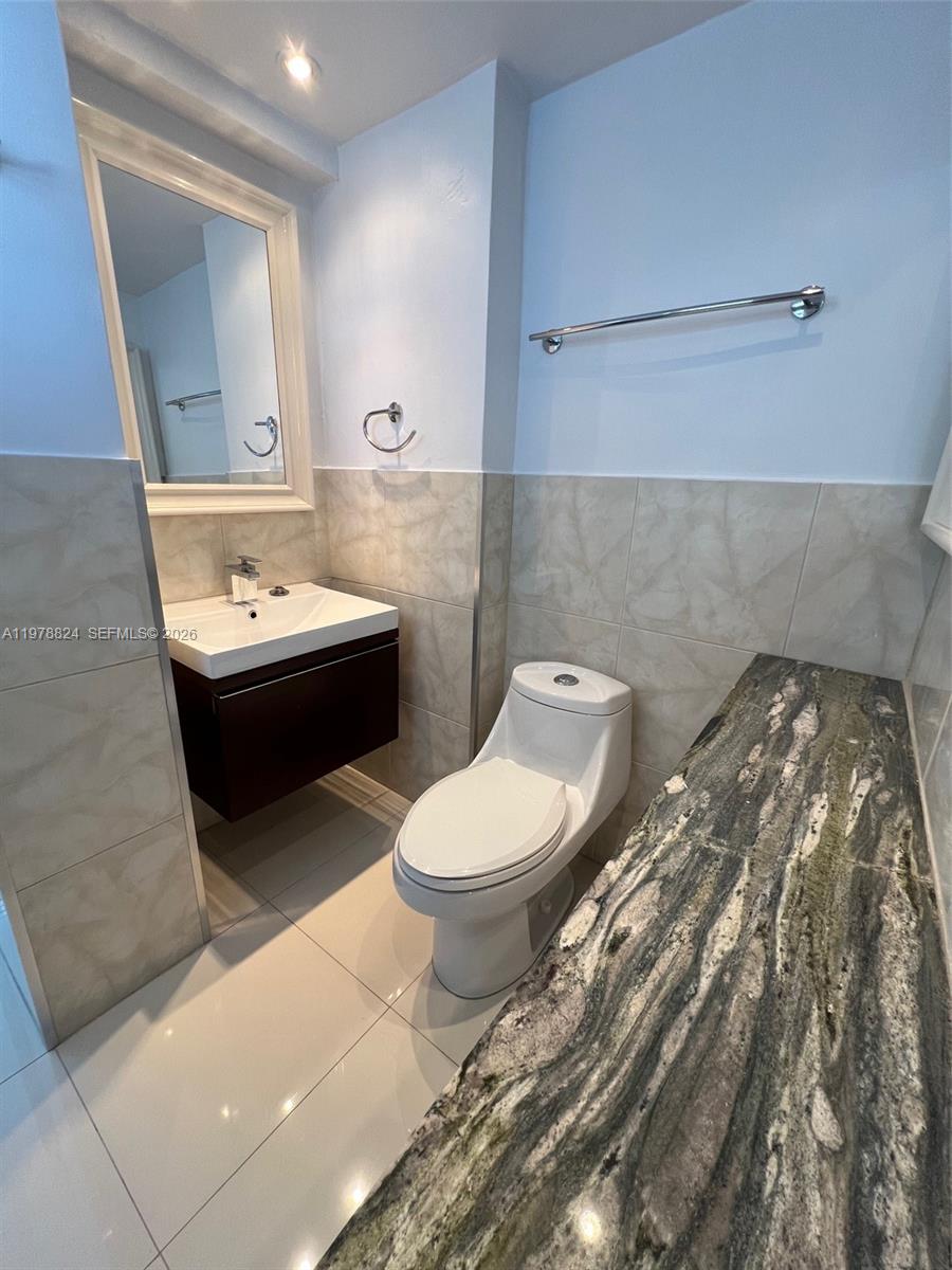 1340 Lincoln Road, Unit 705 Miami Beach, FL 33139 - Photo 3 of 21 a bathroom with a toilet sink and mirror