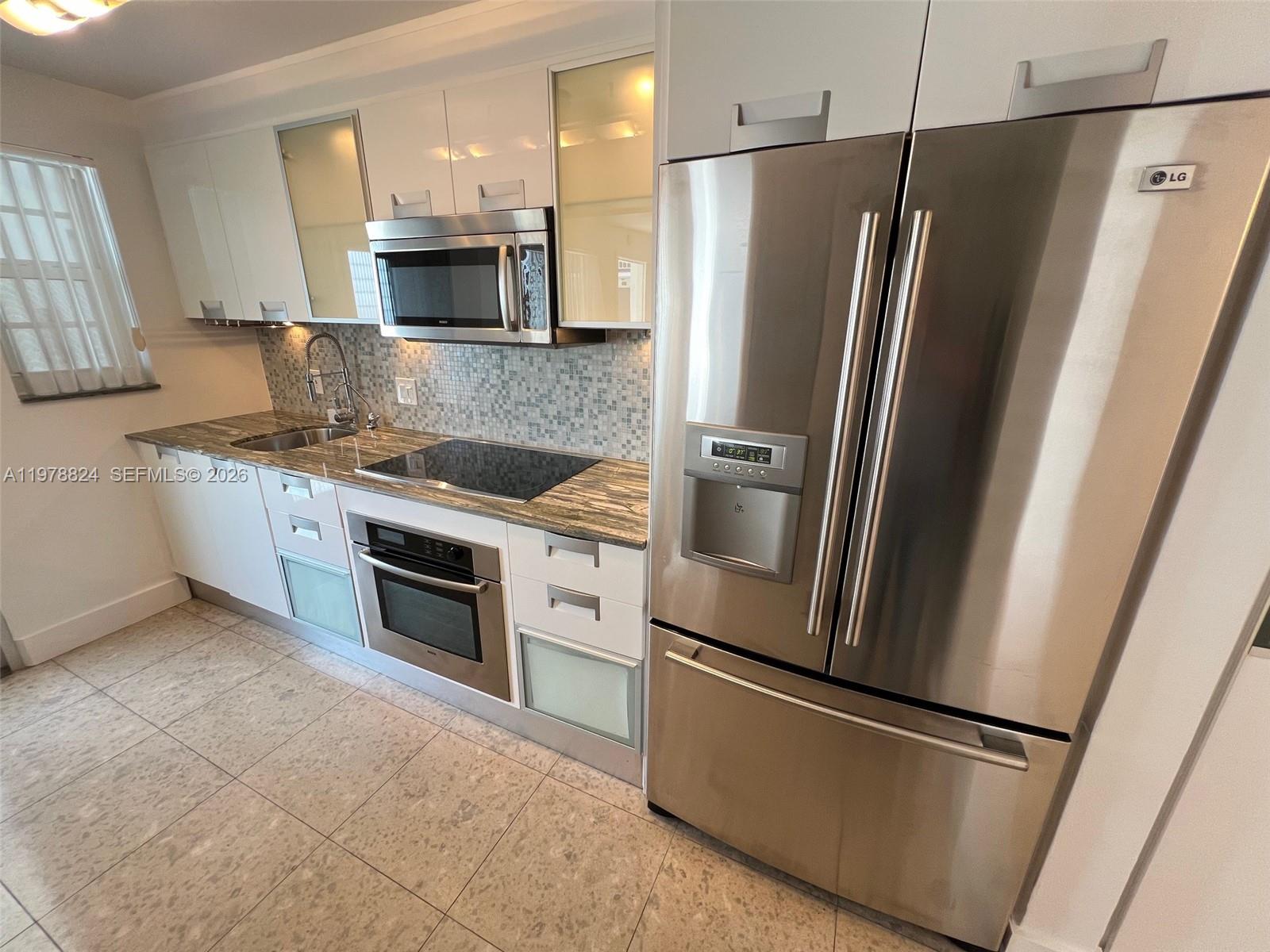 1340 Lincoln Road, Unit 705 Miami Beach, FL 33139 - Photo 8 of 21 a kitchen with stainless steel appliances granite countertop a refrigerator and a stove top oven
