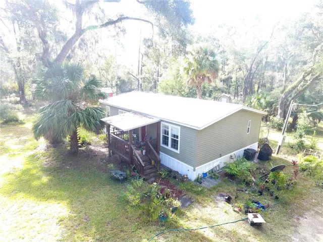 a view of a house with a yard and large tree
