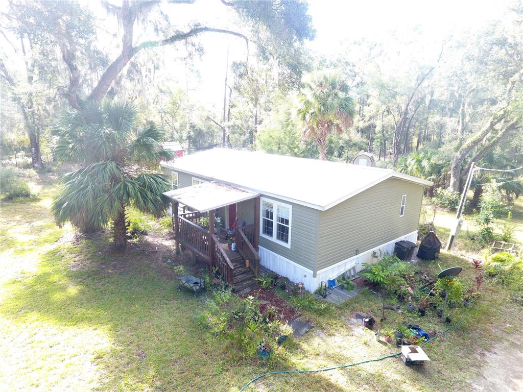 a view of a house with a yard and large tree