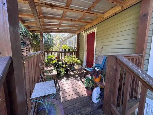 a view of a balcony with chairs and a potted plant