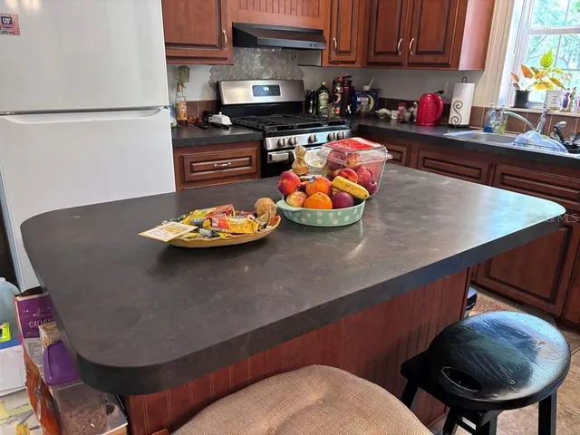 a kitchen with a sink a stove and chairs