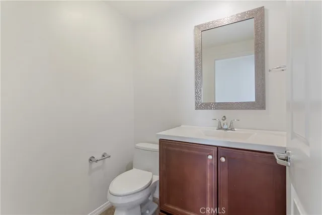 a bathroom with a toilet sink vanity and mirror