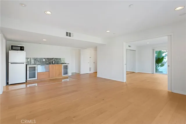 a view of a kitchen with a sink hardwood floor and a refrigerator