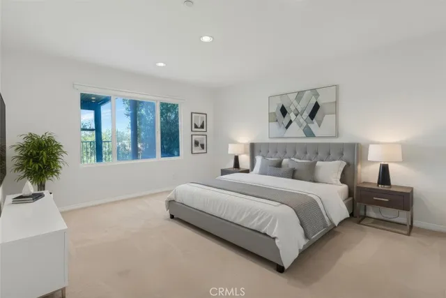 a spacious bedroom with a large bed and a chandelier
