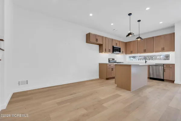 an empty room with wooden floor and window