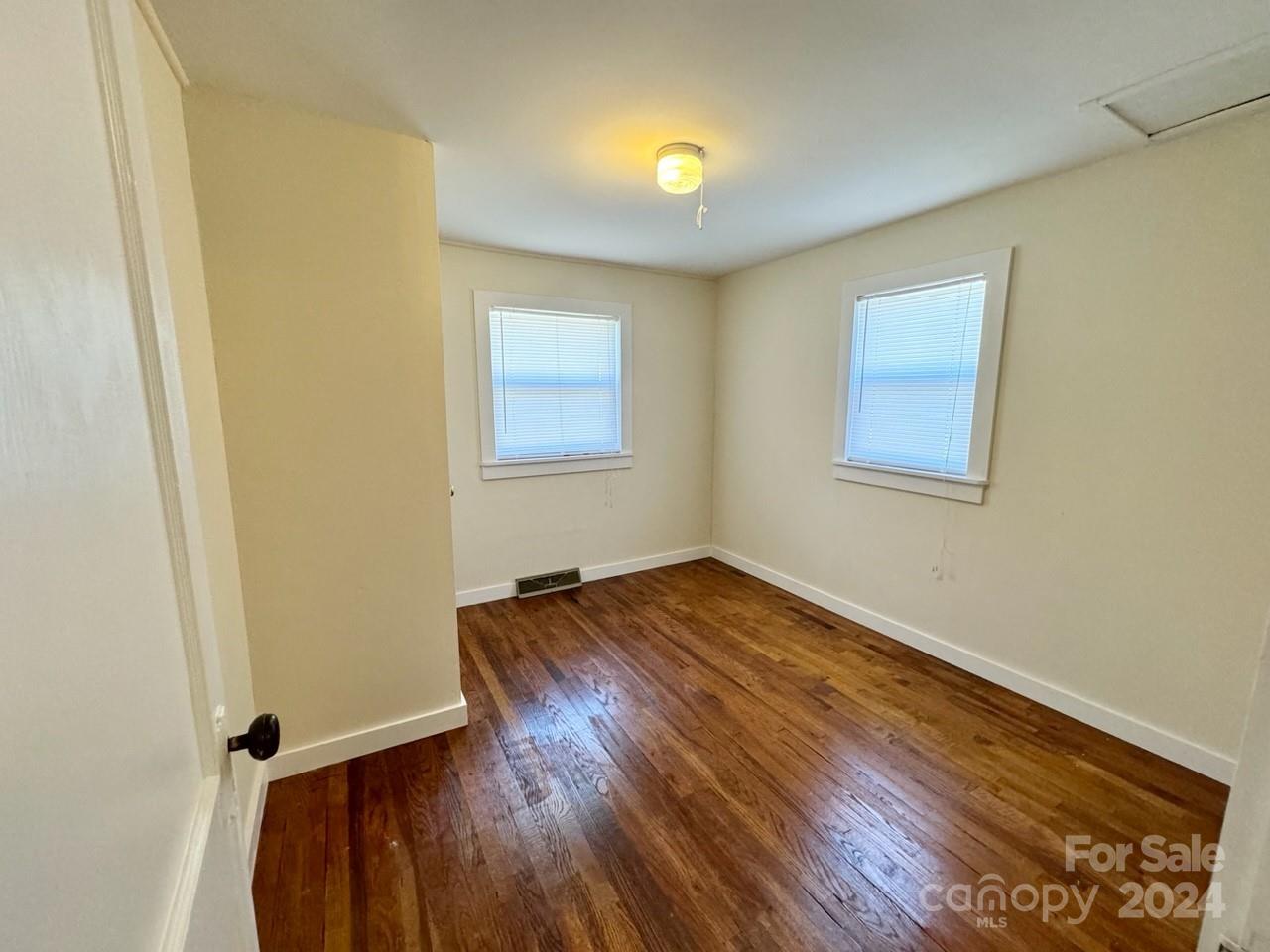 565 Neely Road Brevard, NC 28712 - Photo 15 of 28 an empty room with wooden floor and windows
