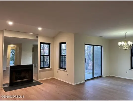 an empty room with windows and fireplace
