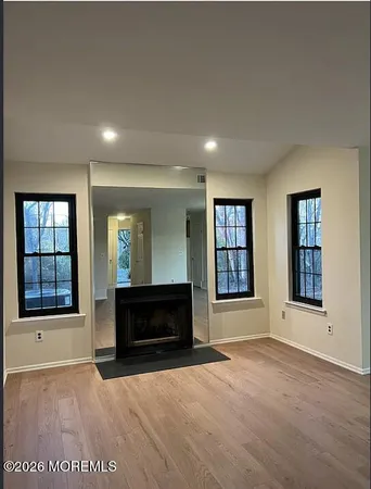 an empty room with windows and fireplace