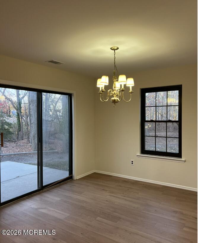 91 Paddock Court Oceanport, NJ 07757 - Photo 4 of 17 an empty room with wooden floor chandelier and windows