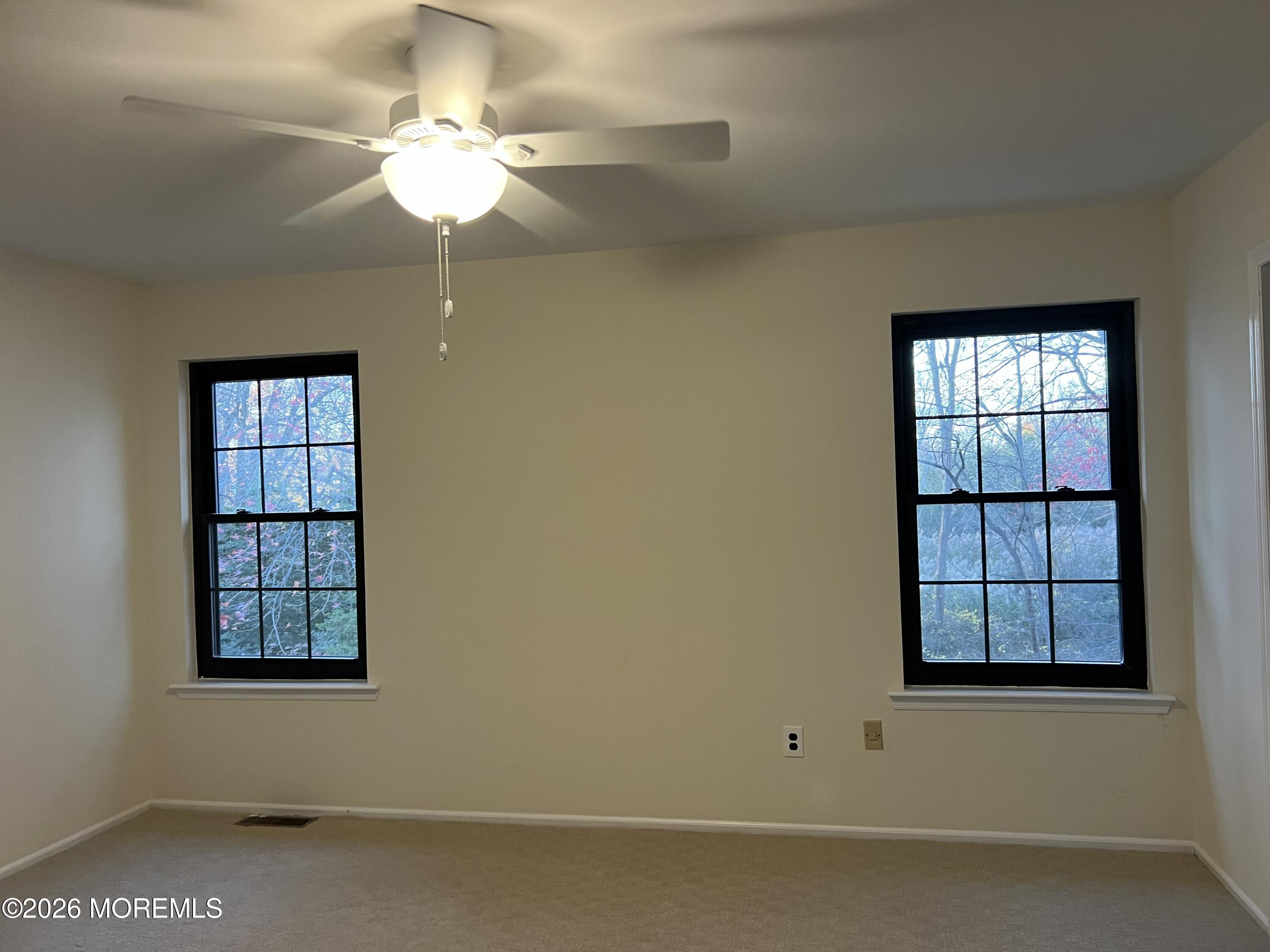 91 Paddock Court Oceanport, NJ 07757 - Photo 5 of 17 an empty room with windows and ceiling fan