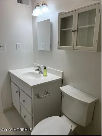 a bathroom with a sink mirror vanity and toilet