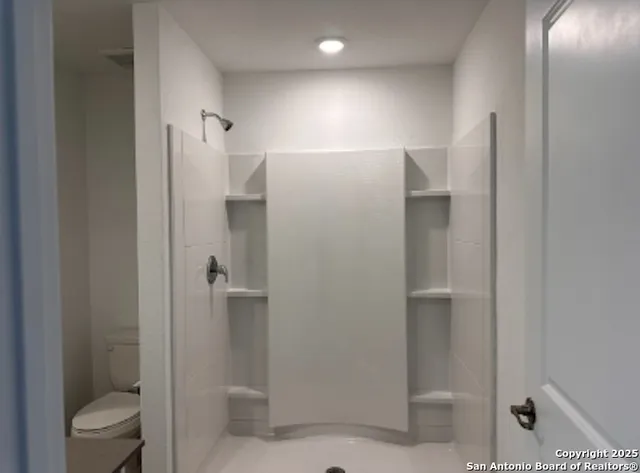 a bathroom with a shower and toilet