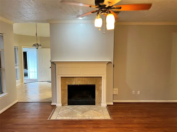 a view of a livingroom with a fireplace and a chandelier fan