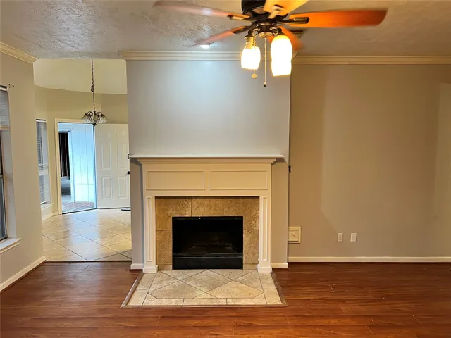 a view of a livingroom with a fireplace and a chandelier fan