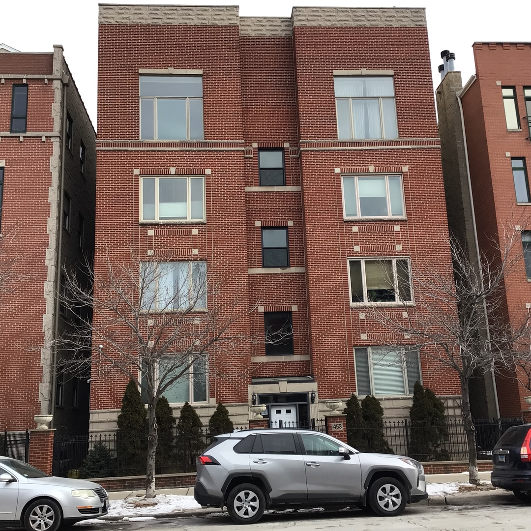 a front view of a building with car parked