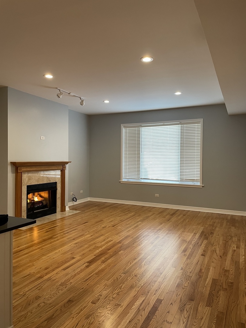 Undisclosed Address Chicago, IL 60642 - Photo 2 of 24 an empty room with wooden floor fireplace and windows