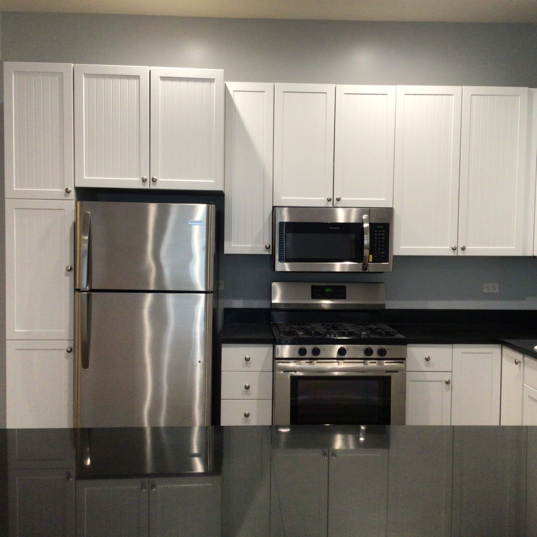 Undisclosed Address Chicago, IL 60642 - Photo 7 of 24 a kitchen with stainless steel appliances a refrigerator stove and microwave