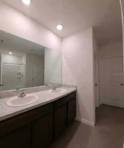 a bathroom with a double vanity sink and a mirror