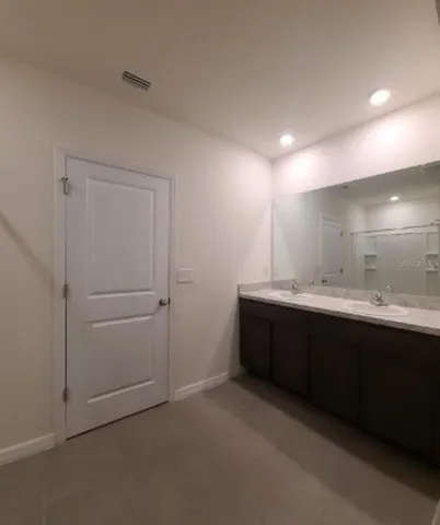 a bathroom with a double vanity sink and mirror