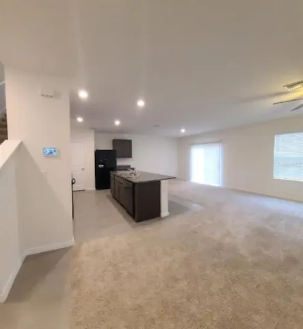 a view of kitchen and kitchen with a sink wooden floor and window