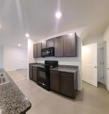 a large kitchen with a stove a sink and a refrigerator