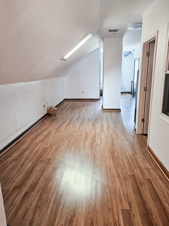 an empty room with wooden floor and a ceiling fan